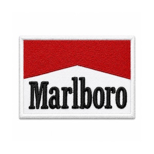 Può includere: Una toppa rettangolare ricamata con una sezione superiore rossa e una sezione inferiore bianca. La parola Marlboro è ricamata in lettere nere, in grassetto e con grazie sulla parte bianca, con un bordo bianco attorno al design.
