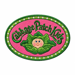 May include: An oval embroidered patch featuring a bright pink background with a green border accented by small white dots. The text Cabbage Patch Kids is stitched in green above a central illustration of a smiling face nestled in green leaves.