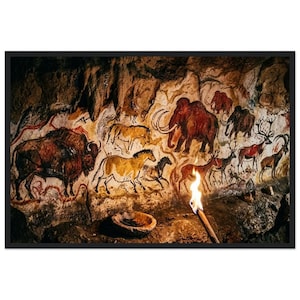 Könnte beinhalten: Ein gerahmter Wandkunstdruck, der prähistorische Höhlenmalereien auf einer strukturierten Steinwand zeigt. Das Kunstwerk enthält detaillierte Illustrationen von Bisons, Mammuts, Pferden und Hirschen in Braun-, Ocker- und Schwarztönen, beleuchtet von einer Fackel.
