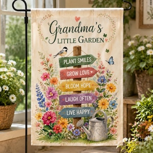 Op de afbeelding: Een rechthoekige tuinvlag met de tekst Grandma's LITTLE GARDEN, een vogel, een vlinder en een metalen gieter. Vijf kleurrijke houten bordjes wijzen in verschillende richtingen met de teksten PLANT SMILES, GROW LOVE, BLOOM HOPE, LAUGH OFTEN en LIVE HAPPY, omringd door diverse bloemen.