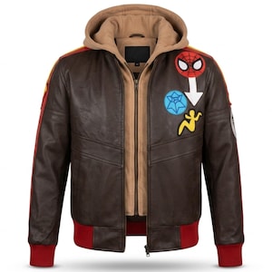 May include: A dark brown leather bomber jacket featuring a tan hooded inner layer, red ribbed cuffs and hem, and various colorful patches on the chest, including a Spider-Man mask, a blue spider web icon, and a yellow silhouette figure.