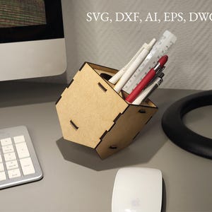 Könnte beinhalten: Ein hölzerner Schreibtisch-Organizer mit geometrischem Design, der Stifte, ein Lineal und einen Bleistift enthält. Der Organizer besteht aus hellbraunem Holz. Der Text im Bild lautet: SVG, DXF, AI, EPS, DWG.