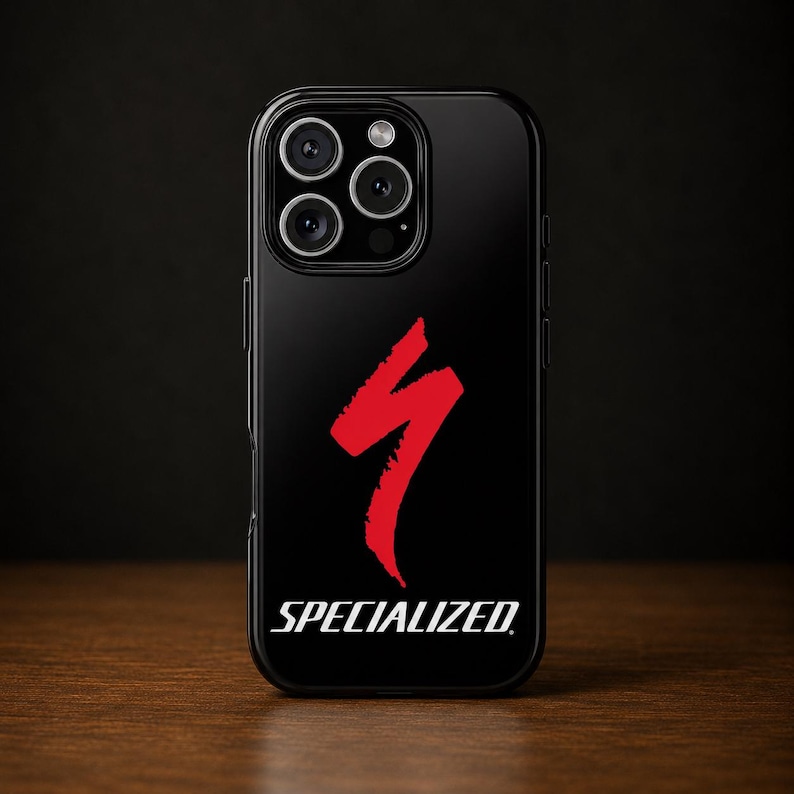 Op de afbeelding: Zwarte telefoonhoes met het Specialized-logo in rood. Het logo is een gestileerde bliksemschicht. Het woord "SPECIALIZED" staat eronder in het wit gedrukt. De telefoonhoes heeft een glanzende afwerking.