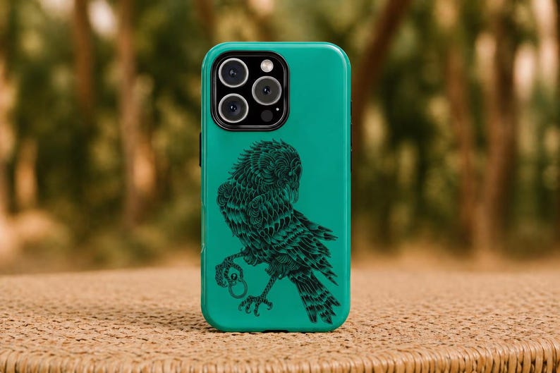 May include: Teal phone case with a black owl illustration. The owl is depicted with intricate detail, holding a ring in its talons. The case has a glossy finish and a camera module with three lenses.