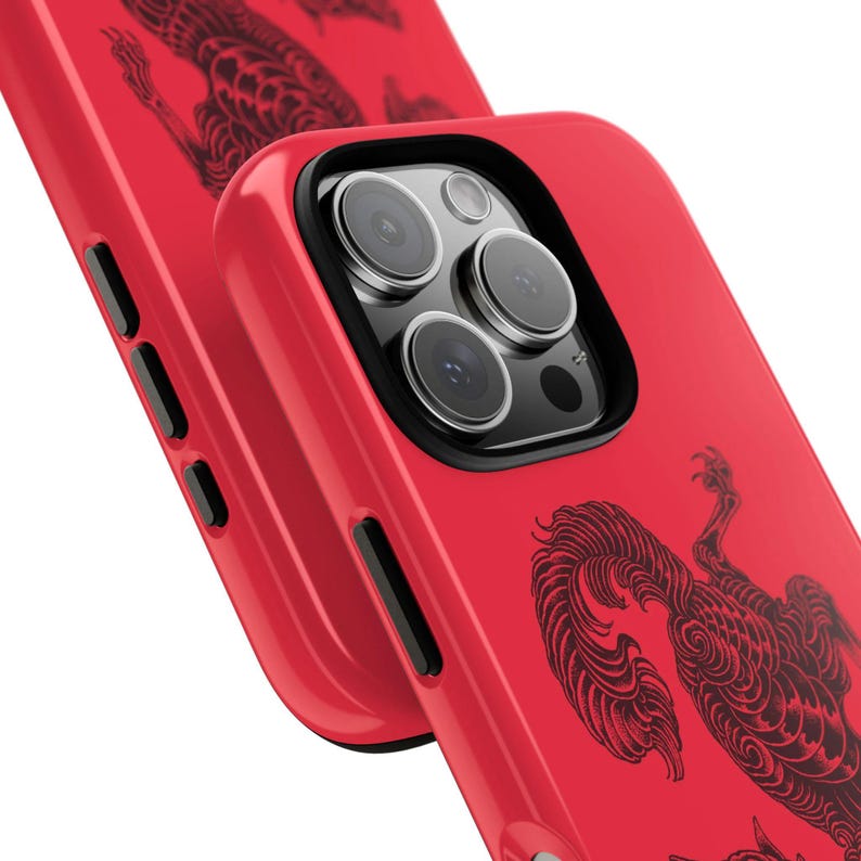 May include: Vibrant red phone case featuring a black illustration of a mythical beast. The case has a black camera lens surround and black side buttons. The phone case is shown at an angle, with a second case in the background.