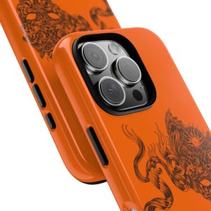 May include: Orange phone case with a black dragon design. The case has a glossy finish and features a camera cutout. The dragon design is detailed and covers a portion of the case.