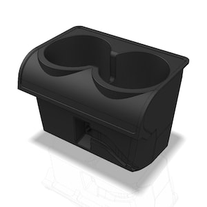May include: A matte black plastic dual cup holder insert featuring two circular recessed compartments for beverage containers. The unit has a rectangular base with a contoured top edge and a small rectangular cutout on the front vertical panel.