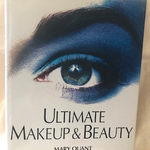 May include: A book cover featuring a close-up of a blue eye with black eyelashes. The title of the book is "Ultimate Makeup & Beauty" by Mary Quant.