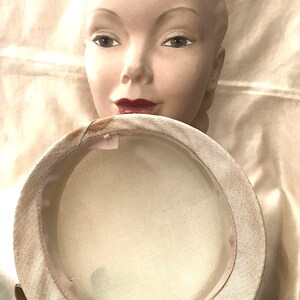 May include: A white hat with a wide brim and a satin lining. The hat is made of a woven material and has a slightly rounded crown.