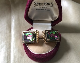 Könnte beinhalten: Ein Paar goldfarbene Vintage-Manschettenknöpfe mit schillernden rechteckigen Steinen, präsentiert in einer offenen bordeauxroten Samtbox. Die Box zeigt das Etikett Spector's Jewelers.