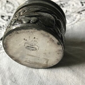 May include: Silver plated cup with an embossed floral design. The bottom of the cup is marked "Rogers & Smith, Meriden, CT, Quadruple".