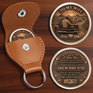 May include: A tan leather keychain pouch with a silver snap button and a circular metal insert featuring a couple sitting in a truck bed with the text To My Wife, Henry, and Emily. A second circular metal piece displays the text Never Forget That I Love You, I Gave My Heart To You, You Are My Best Friend, My Soulmate, My Everything, I Love You.