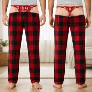 May include: A pair of lounge trousers featuring a red and black buffalo check pattern. The waistband area displays a printed graphic of a red and white snowflake-patterned thong over a skin-toned background, creating a humorous trompe l'oeil effect.