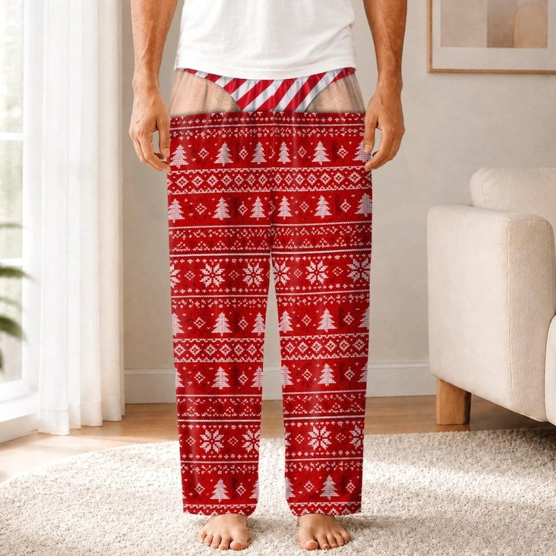 May include: Lounge trousers featuring a red and white holiday-themed pattern with repeating Christmas trees and snowflake motifs. The waistband area displays a graphic print of red and white diagonal stripes, creating the appearance of a thong.