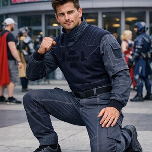May include: A dark navy blue tactical-style long-sleeve shirt and matching cargo pants set. The shirt features a high collar, white contrast stitching, and a structured chest panel. The pants include side pockets and white stitching details.