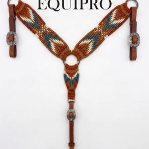 May include: A brown and turquoise woven horse breast collar with leather straps and silver buckles. The breast collar has a geometric pattern and the word "EQUIPRO" is printed at the top.