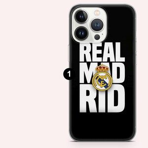 Puede incluir: Funda de tel&eacute;fono negra con la inscripci&oacute;n blanca "REAL MAD RID". El logotipo del Real Madrid, con corona y emblema dorados, est&aacute; centrado. Dise&ntilde;ado para un smartphone.