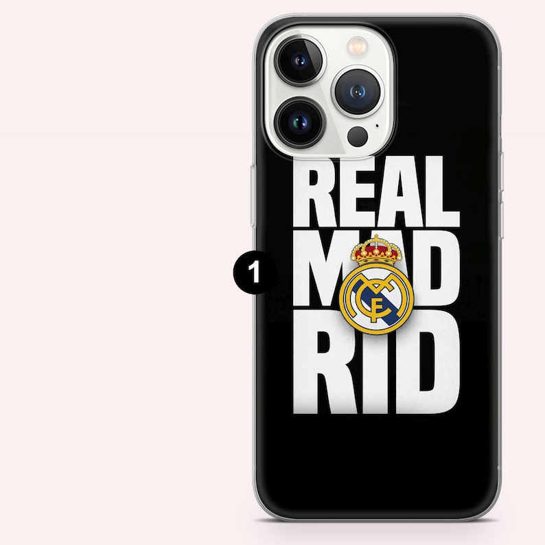 Puede incluir: Funda de tel&eacute;fono negra con la inscripci&oacute;n blanca "REAL MAD RID". El logotipo del Real Madrid, con corona y emblema dorados, est&aacute; centrado. Dise&ntilde;ado para un smartphone.