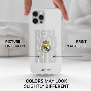 Puede incluir: Una funda blanca para tel&eacute;fono con el logotipo y el nombre del equipo del Real Madrid en gris. La funda tiene un dise&ntilde;o claro y protector. El texto "COLORS MAY LOOK SLIGHTLY DIFFERENT" est&aacute; impreso en la parte inferior.