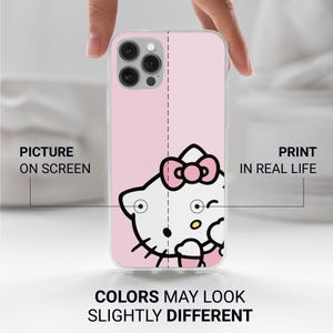 Puede incluir: Una funda de tel&eacute;fono rosa con un dise&ntilde;o de Hello Kitty. La funda tiene un gr&aacute;fico de Hello Kitty blanco con un lazo rosa. Los textos "Picture on Screen" y "Print in Real Life" son visibles. Tambi&eacute;n est&aacute; presente el texto "Colors May Look Slightly Different".