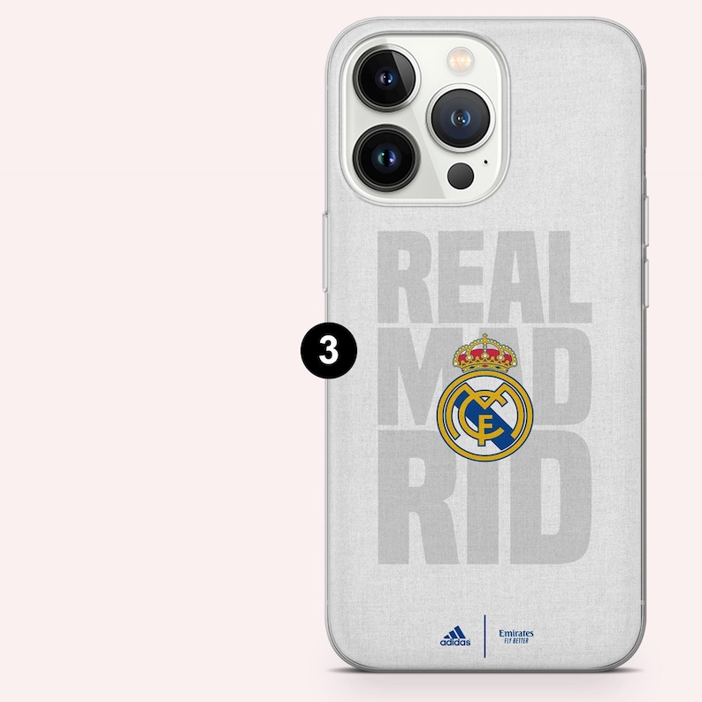 Puede incluir: Una funda blanca para tel&eacute;fono con las palabras "REAL MADRID" en gris, con el escudo del equipo en el centro. La funda tambi&eacute;n presenta los logotipos de Adidas y Emirates Fly Better en la parte inferior.