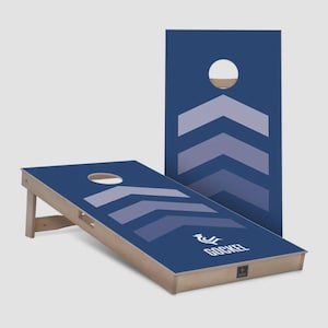Könnte beinhalten: Ein marineblaues Cornhole-Set mit einem Chevron-Design in Blautönen und einem kreisförmigen Loch. Das Set besteht aus zwei Holzbrettern. Der Markenname "GOCKEL" ist auf dem Brett aufgedruckt.