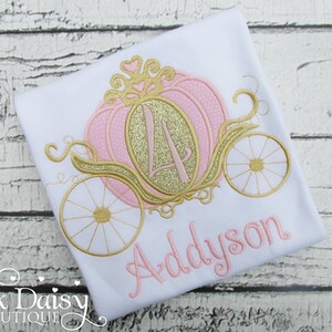 May include: A white t-shirt with a pink and gold embroidered pumpkin carriage and the name Addyson.