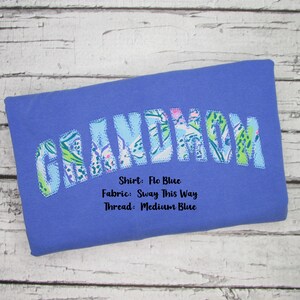 May include: A blue shirt with the word "GRANDMOM" in a floral pattern. The shirt's color is "Flo Blue", the fabric is "Sway This Way", and the thread is "Medium Blue".