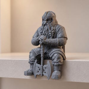 May include: A grey resin figurine of a seated dwarf warrior wearing detailed plate armour and a helmet. The figure features a long braided beard and holds a large double-bladed battle axe with both hands resting on the handle between the legs.