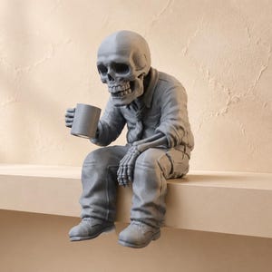 May include: A grey monochromatic figurine of a skeleton wearing a collared shirt, a necktie, and trousers. The skeleton is in a seated position, holding a cylindrical mug in one hand while resting the other hand on its knee, wearing lace-up shoes.