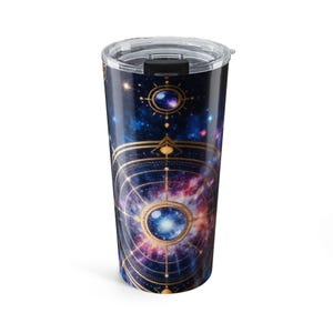 May include: A cylindrical stainless steel tumbler featuring a deep space nebula print in shades of blue, purple, and pink. The exterior is decorated with gold-colored geometric celestial navigation lines and circular orbs. It has a clear plastic lid.