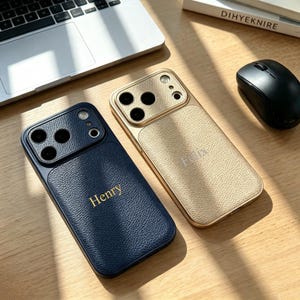 Op de afbeelding: Twee smartphonehoesjes met een gestructureerde, leerachtige afwerking en een uitsparing voor de camera. Het donkerblauwe hoesje heeft de naam Henry in gouden letters, terwijl het goudkleurige hoesje de naam Felix in goud bevat.