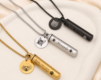 May include: Three cylindrical pendant necklaces in gold, silver, and black tones. Each features a matching chain, a circular charm engraved with a pet portrait, and a tube pendant engraved with names, dates, and paw prints. Text includes Buddy 2011-2018, Always with me, and Miranda.