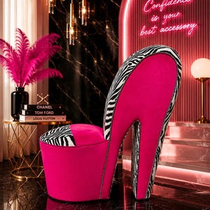 May include: A high-heel shoe shaped chair upholstered in vibrant hot pink velvet and black and white zebra print fabric. The chair features a tall backrest, a rounded seat, and a tall stiletto heel base, accented with silver nailhead trim.