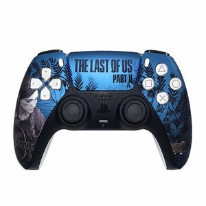 Puede incluir: Un mando de juego inalámbrico azul y negro con un gráfico de una persona sosteniendo una guitarra en el lado izquierdo, un patrón de hojas de helecho azul oscuro y el texto THE LAST OF US PART II impreso en negro sobre el panel táctil.