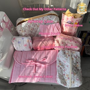 May include: A collection of quilted fabric accessories including an Airwrap case, a pleated pouch, a book sleeve, boxy cosmetic pouches, and a MacBook sleeve in pink gingham and floral patterns. Text overlays include Check Out My Other Patterns.
