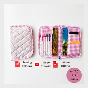May include: A pink and white gingham fabric organizer case with a quilted floral cover. The open case features multiple interior pockets holding pens, a notebook, and a smartphone. Text includes PDF Sewing Pattern, Video Tutorial, PDF Photo Tutorial, and A4/A0 US Letter.