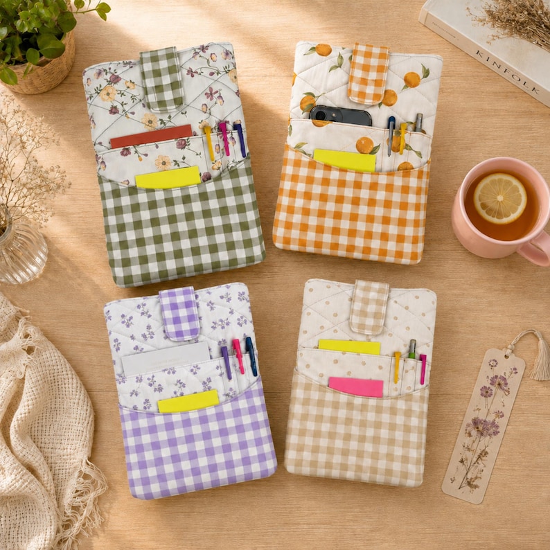 May include: Four rectangular quilted fabric pouches with snap-button closures. Each pouch features a top section with floral or fruit patterns and a bottom section with a gingham check pattern in green, orange, purple, or beige, including pen slots.
