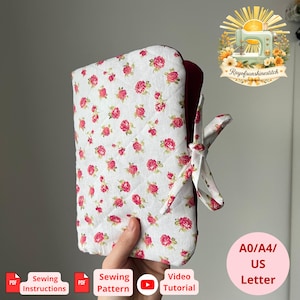 May include: A quilted fabric cover featuring a white background with a repeating pattern of small pink roses. The cover has a deep burgundy interior lining and is secured with matching fabric ties. The design includes a visible diamond-shaped quilting stitch pattern throughout the exterior fabric.