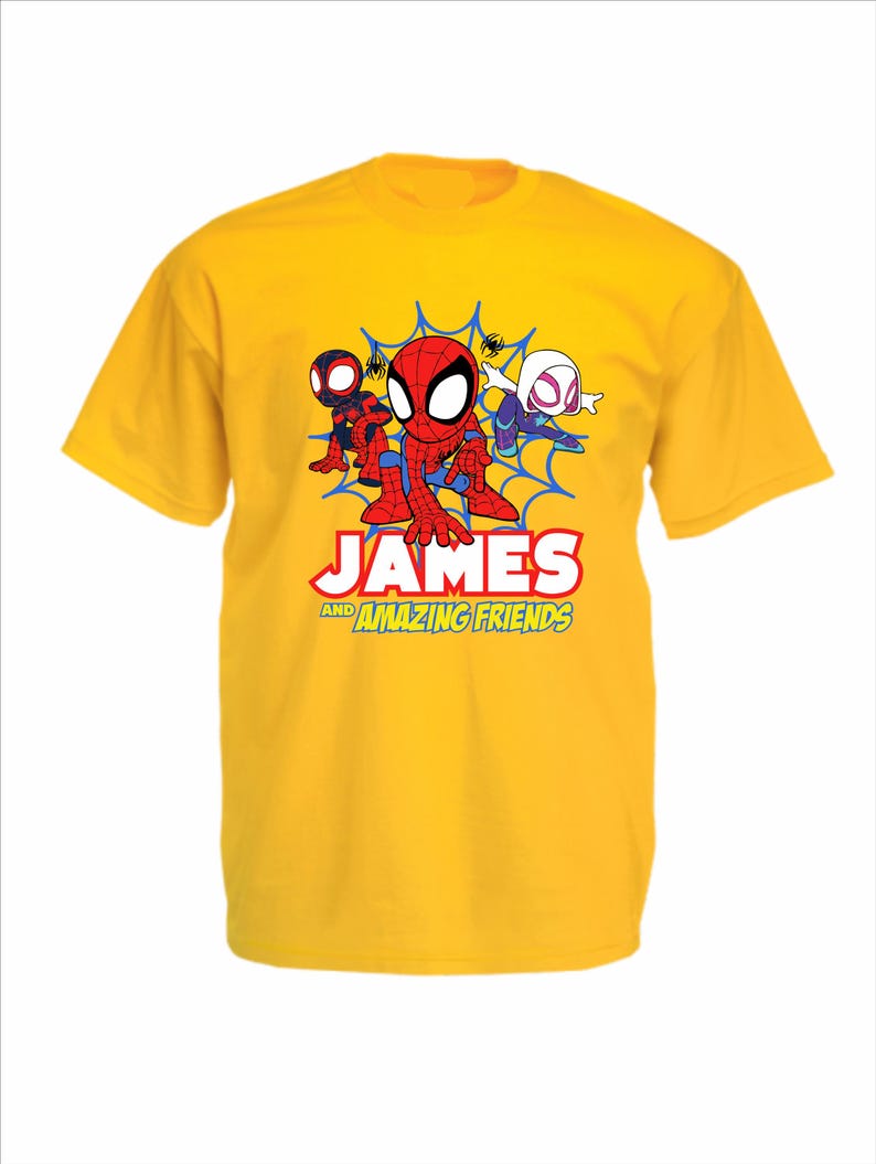 May include: A bright yellow short-sleeved t-shirt featuring a graphic of three cartoon spider-themed characters in front of a blue web. Below the characters, the text reads "JAMES AND AMAZING FRIENDS" in bold red, white, and yellow lettering.