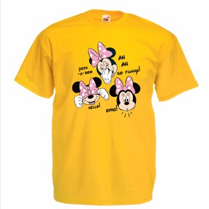 Op de afbeelding: Een gele t-shirt met drie Minnie Mouse cartoon gezichten met roze strikken. Tekst bevat "Peek-a-boo", "Hello!", "Ah ah so funny!" en "OMG!". Het shirt is gemaakt van een zacht materiaal.