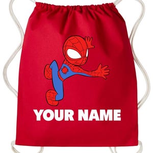 May include: A bright red drawstring backpack featuring a cartoon illustration of a red and blue spider-themed character in a dynamic pose. Below the character, the text YOUR NAME is printed in bold white capital letters. The bag has white cords.