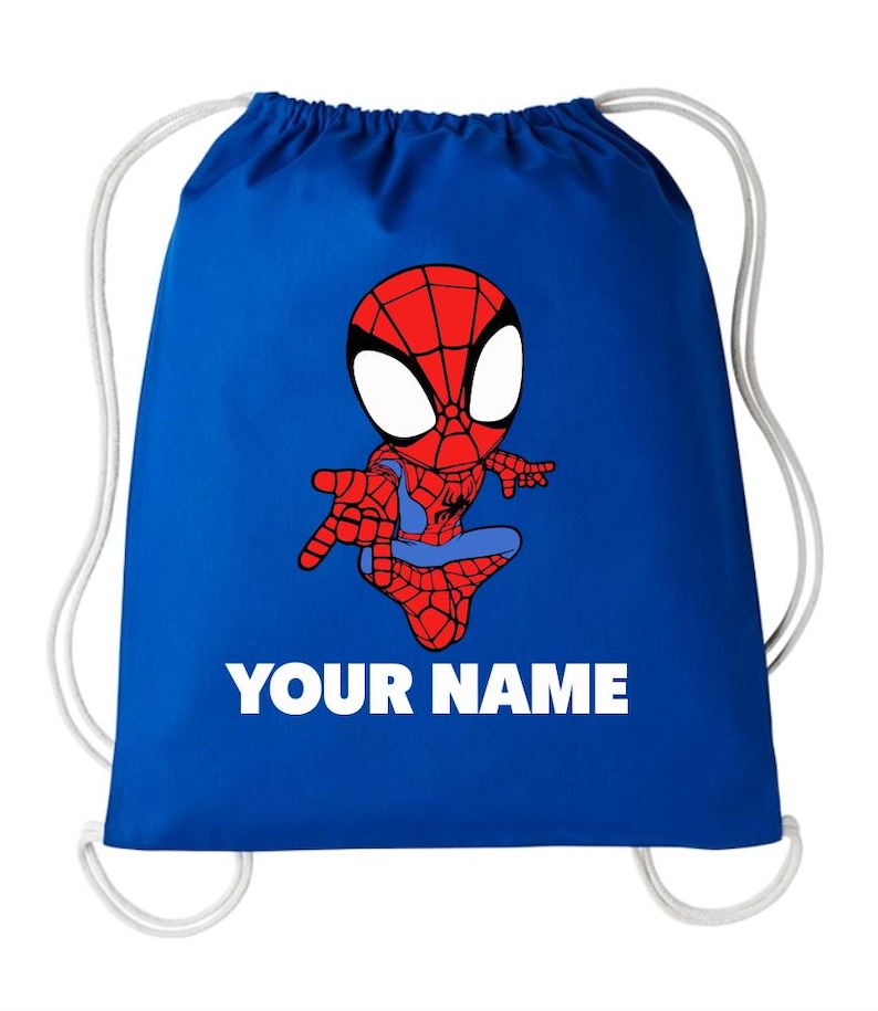 May include: A royal blue drawstring backpack featuring a cartoon illustration of a red and blue spider-themed character in a web-patterned suit. Below the character, the text "YOUR NAME" is printed in bold, white, uppercase sans-serif letters.