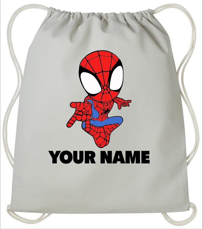 May include: A light gray drawstring backpack featuring a cartoon illustration of a red and blue superhero character with large white eyes. Below the character, the text "YOUR NAME" is printed in bold, black, capital letters on the bag surface.