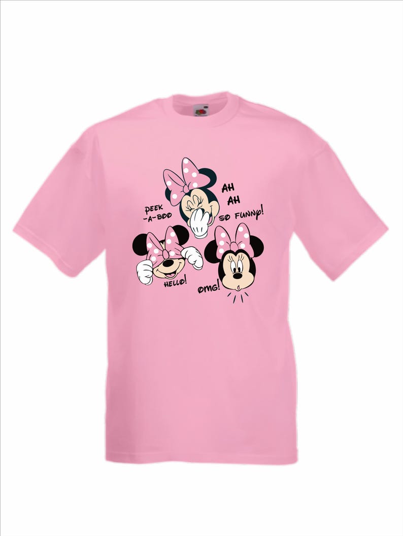 Op de afbeelding: Lichtroze T-shirt met drie Minnie Mouse-afbeeldingen met stippen strikken. Tekst bevat "Peek-a-boo", "Hello!", "Ah, ah, so funny!" en "OMG!"
