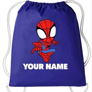 May include: A royal blue drawstring backpack featuring a cartoon illustration of a red and blue spider-themed character in a crouching pose. Below the character, the text "YOUR NAME" is printed in bold, white, capital letters.