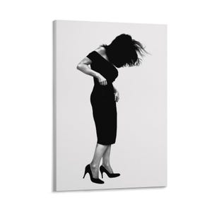 May include: A black and white canvas print featuring a silhouette of a figure wearing an off-the-shoulder black dress and high-heeled shoes. The figure is leaning forward with hair flowing, captured against a plain, light-colored background.