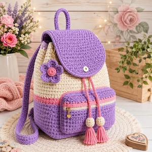 Può includere: Uno zaino all'uncinetto con patta superiore viola, corpo principale color crema e base viola con una striscia rosa. Include una tasca frontale con cerniera, un ciondolo a forma di fiore viola e due lunghi cordini con nappe beige.