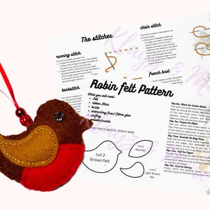 Può includere: Un ornamento in feltro a forma di pettirosso marrone e rosso con nastro rosso e perline, accompagnato da un foglio di istruzioni intitolato Robin felt Pattern, che include diagrammi per i punti e un elenco di materiali come 20cm di nastro.