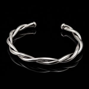 Può includere: Un bracciale rigido color argento lucido caratterizzato da un design a corda intrecciata. Il bracciale aperto è composto da due fili metallici intrecciati che formano un motivo a spirale continuo, terminando con tappi lisci e arrotondati.